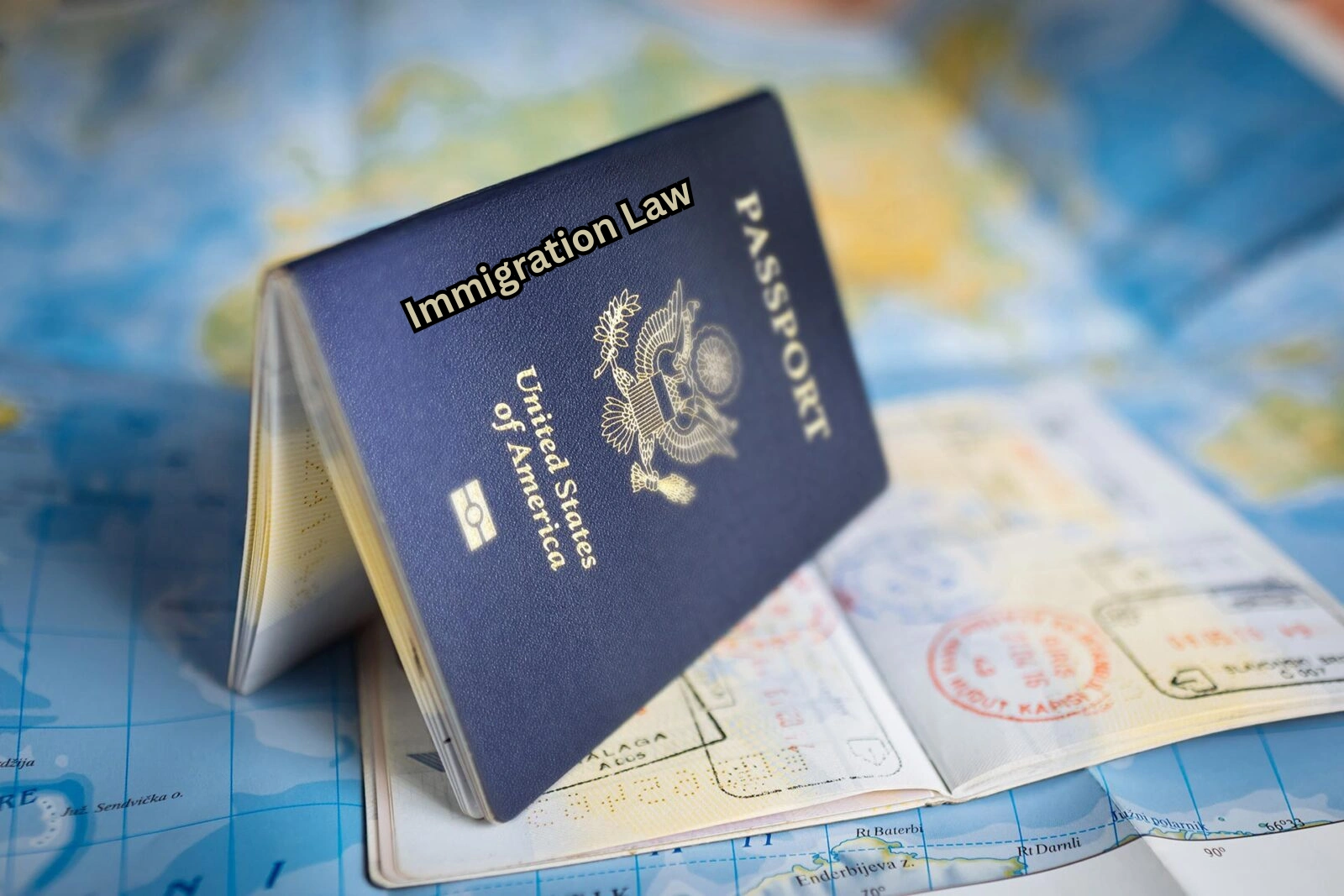 United States passport on an open map with visa stamps, representing immigration law and international travel.